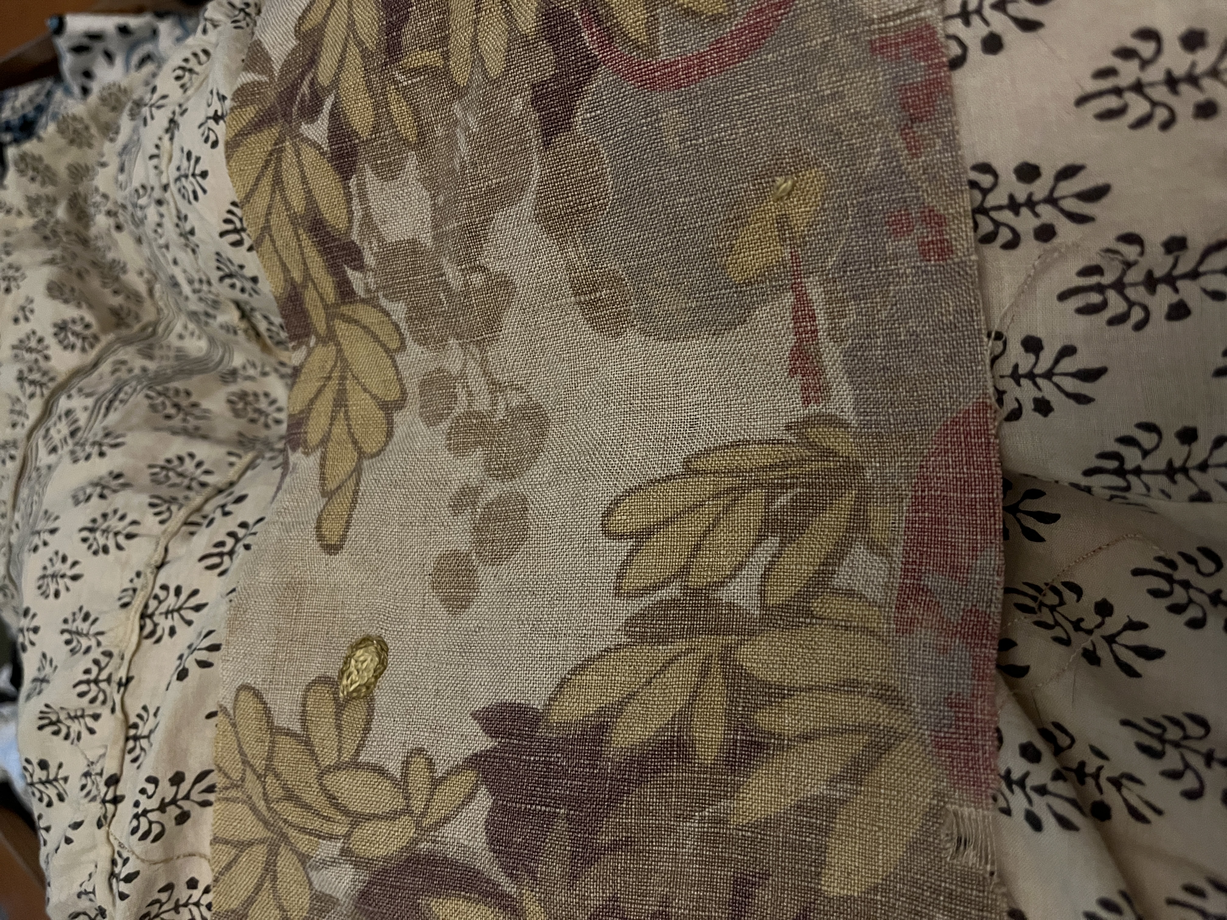 a piece of the printed fabric. An extra leaf has been added with chain stitch embroidery, using colors that match thee primted leaves. A tiny hole has been covered with three small stitches.